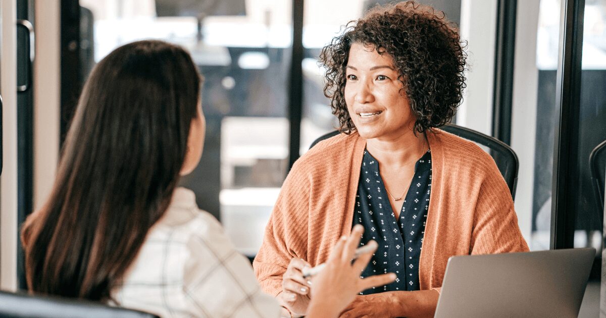 duas mulheres conversam durante um lnt, que é o levantamento de necessidades de treinamento